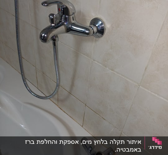 ברז אמבטיה עם צינור מקלחת על קיר קרמיקה